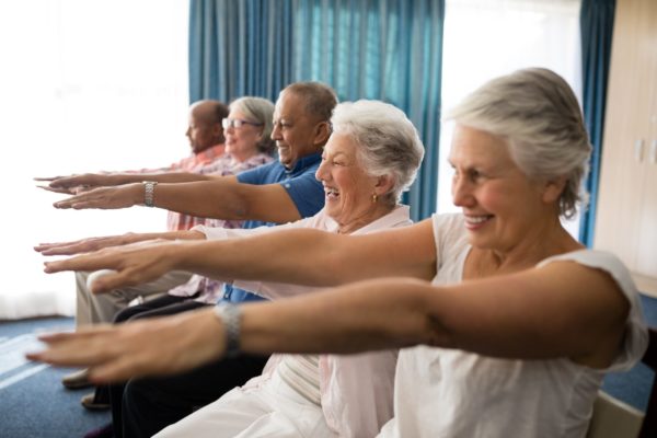 des personnes âgées souriantes font de l'exercice